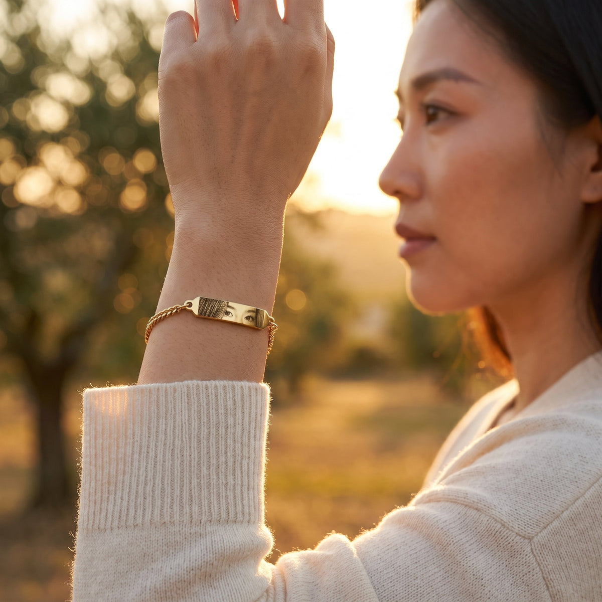 Woman wearing the gold eye bracelet with photo engraving